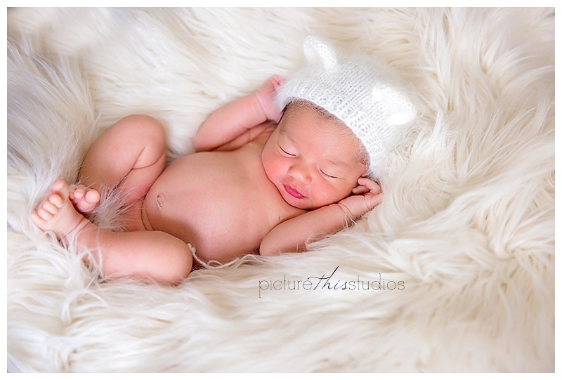 baby in white fur with white hat