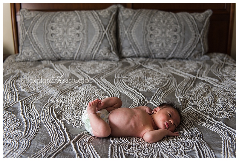 grey bed with newborn baby 